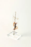 Clear arched acrylic bookmark with Capricorn zodiac lettering, constellation artwork, botanical details, the quote “A dreamer building her own next chapter,” and dangling star and Capricorn heart charms. standing on white background